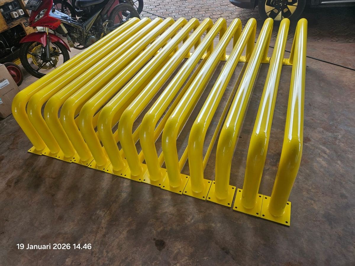 Rangka besi cat kuning dengan batang melengkung sejajar hasil fabrikasi PT Andalan Mega Teknik