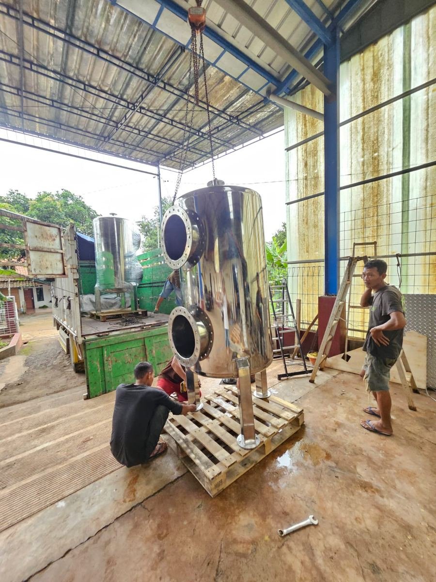 Tim memindahkan tangki stainless steel di area workshop untuk disiapkan pengirimannya